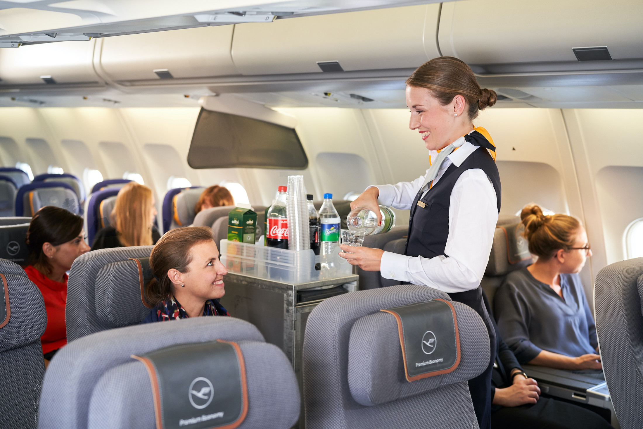 a woman serving drinks on an airplane