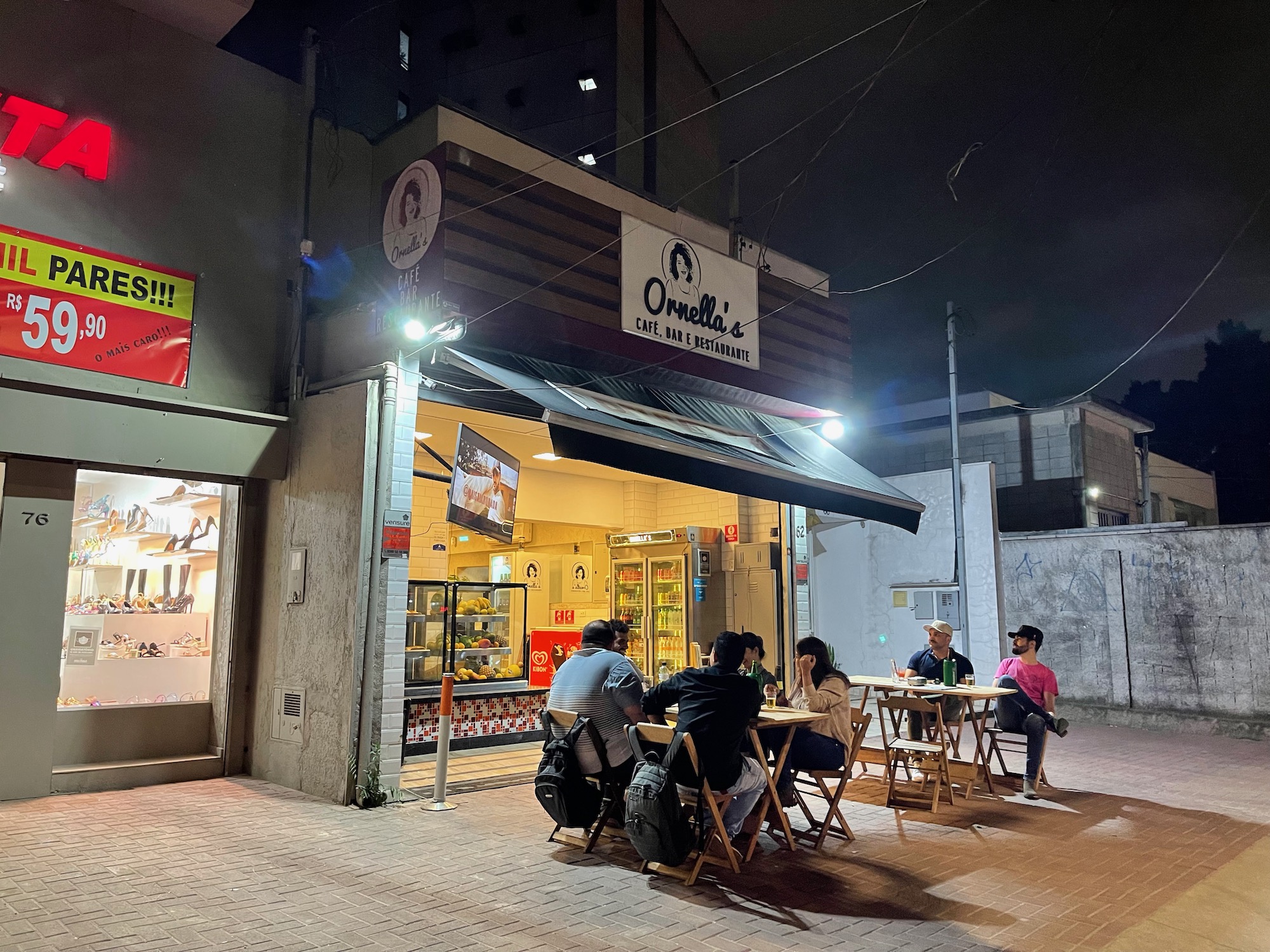 a group of people sitting at tables outside a store