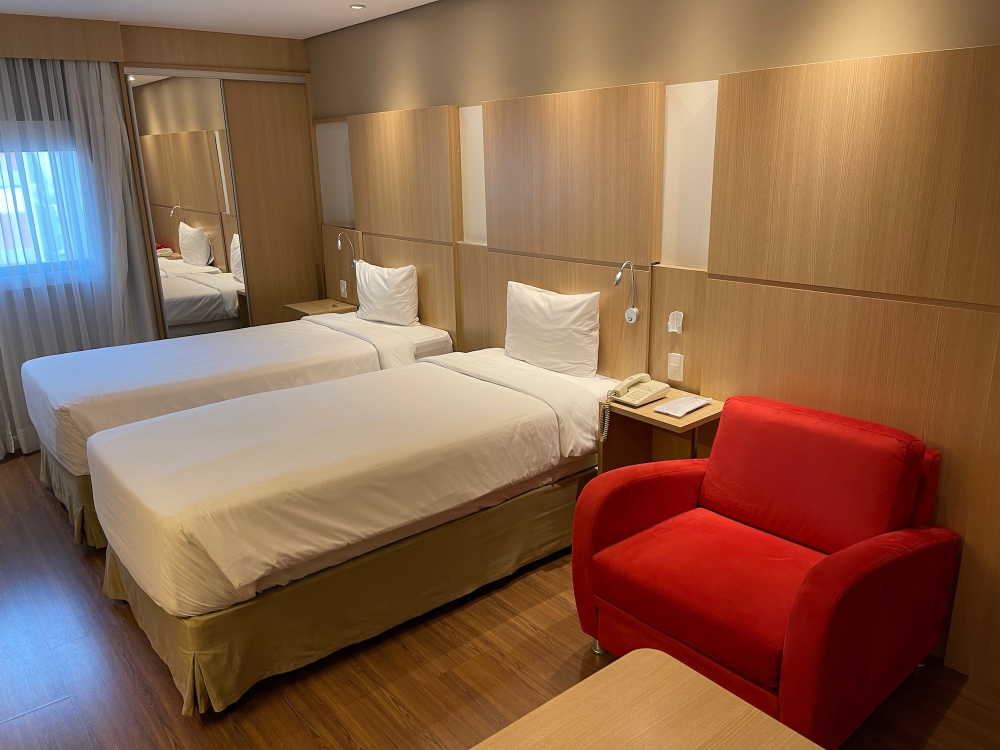 a room with two beds and a red chair