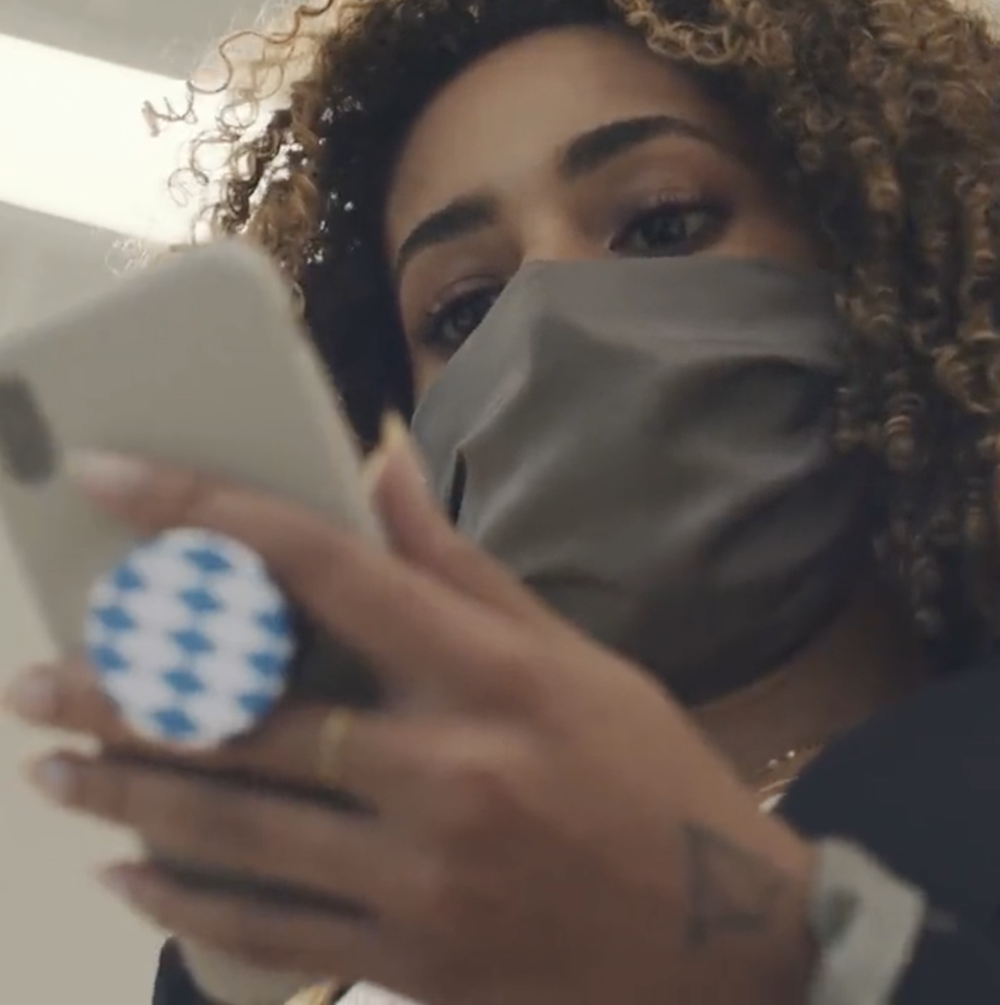 a woman wearing a mask and holding a phone