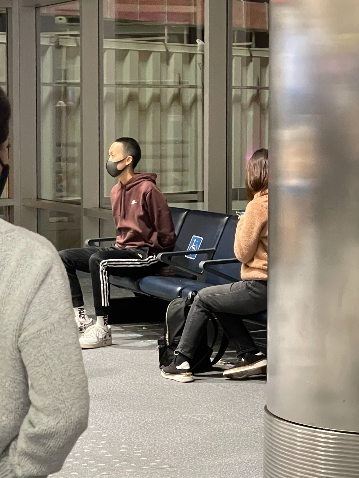 a man wearing a face mask sitting on a bench