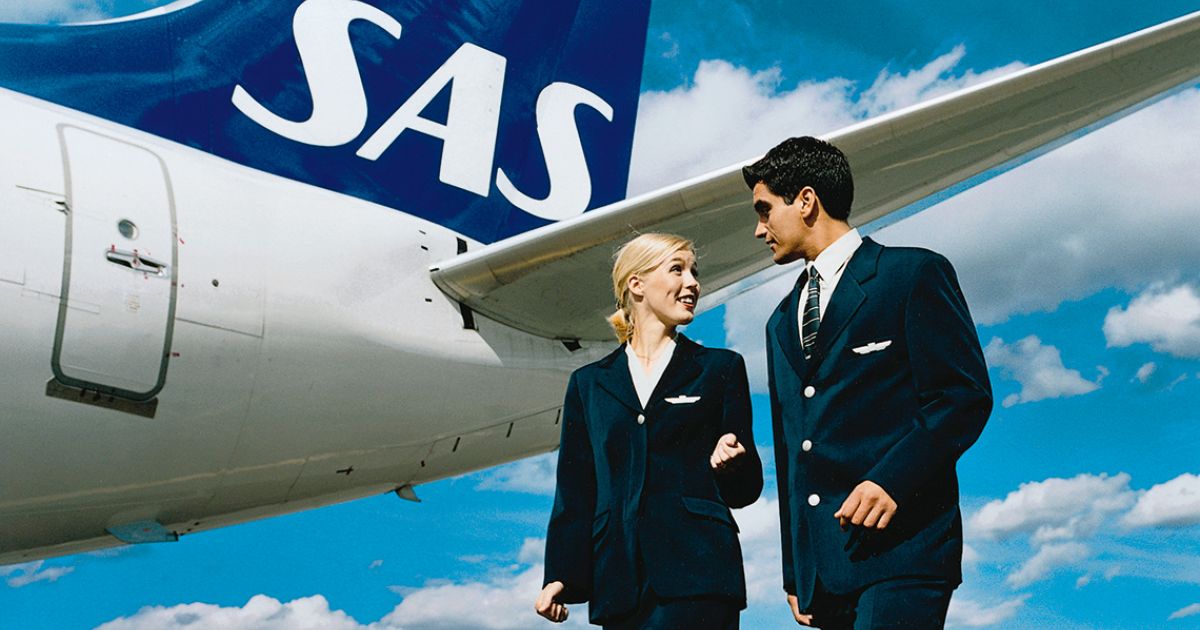 a man and woman in uniform standing next to an airplane