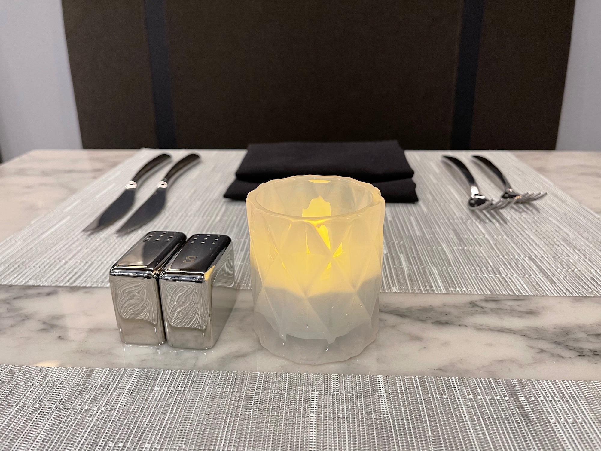 a candle and salt and pepper shakers on a table