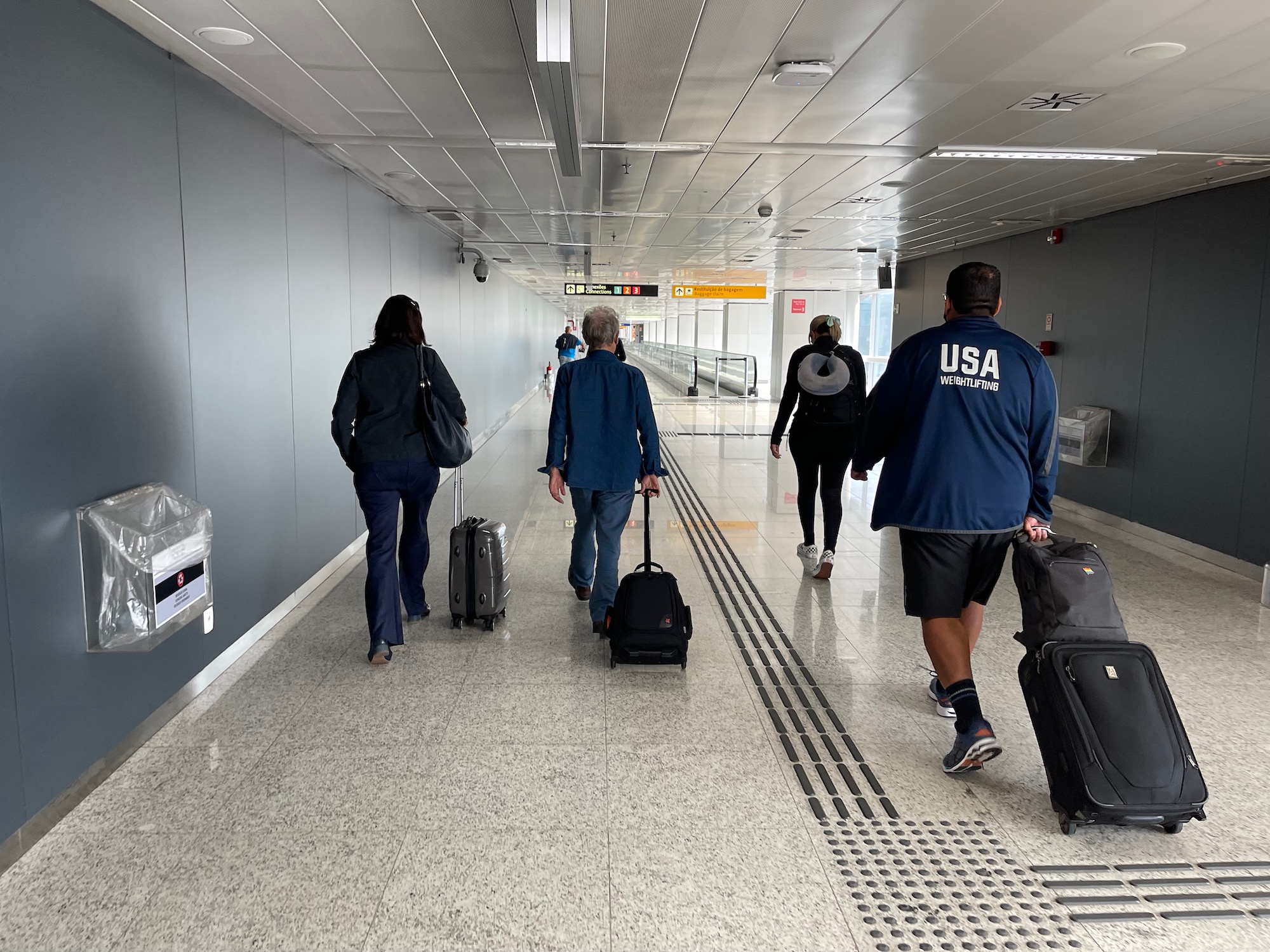 people walking in a hallway with luggage