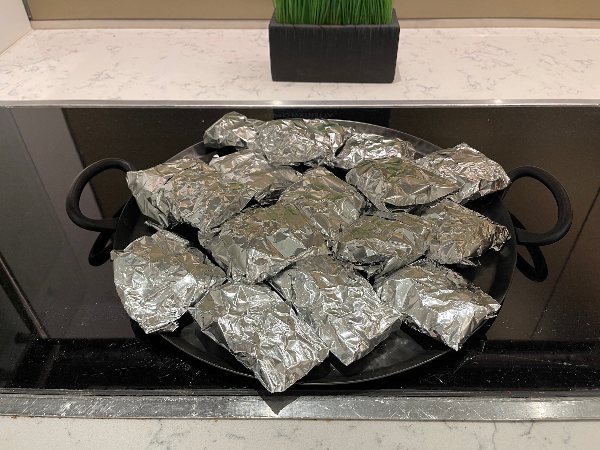 a pan of foil wrapped food on a stove