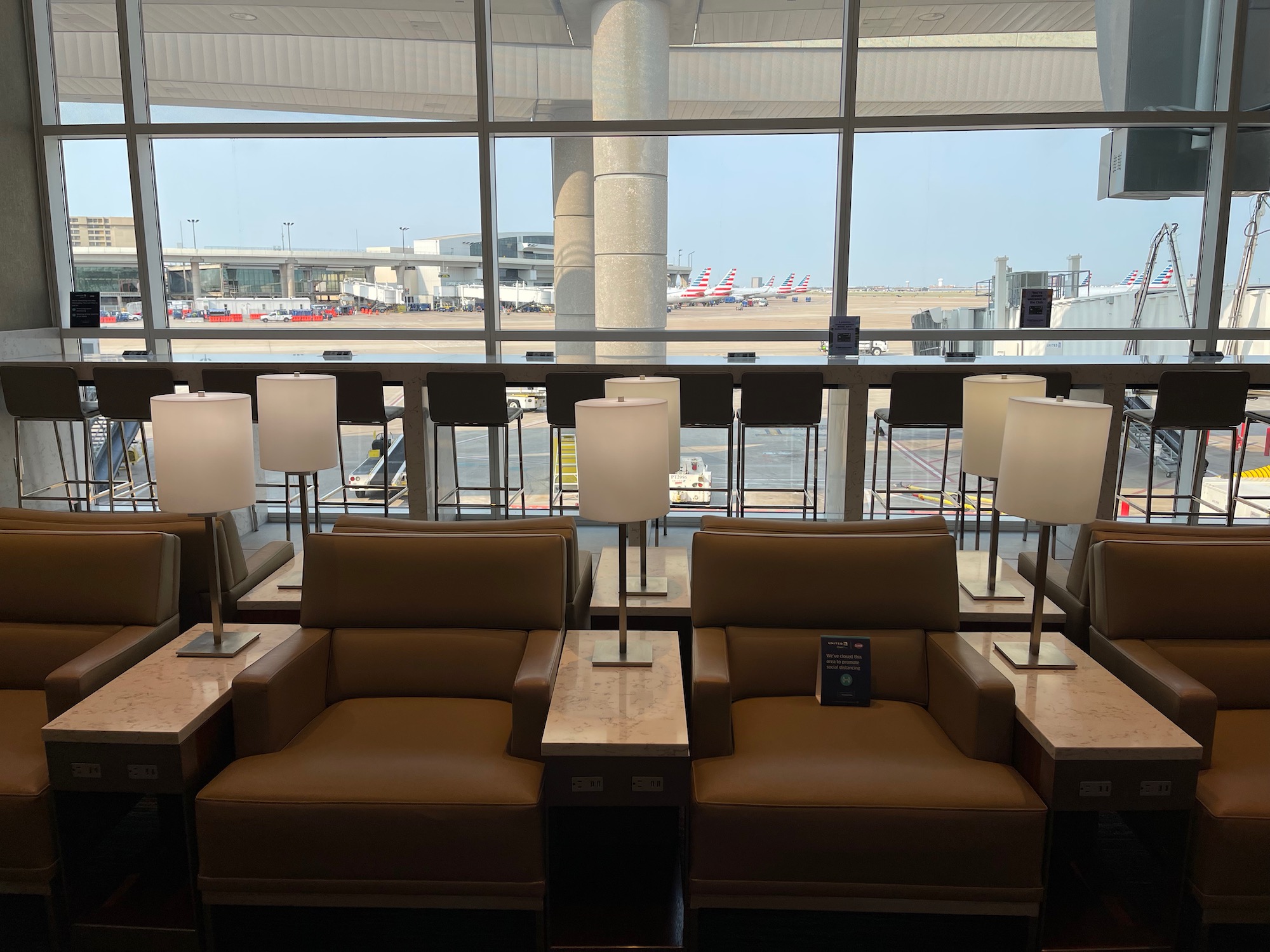 a row of chairs with lamps in a room with windows