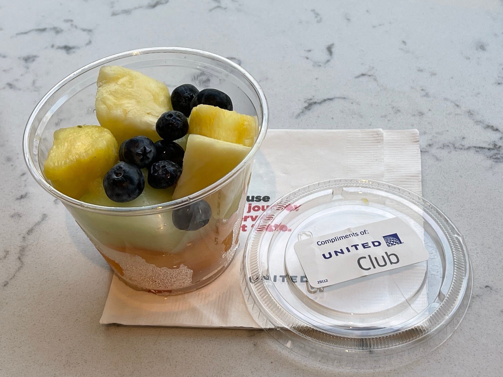 a cup of fruit and a plastic container