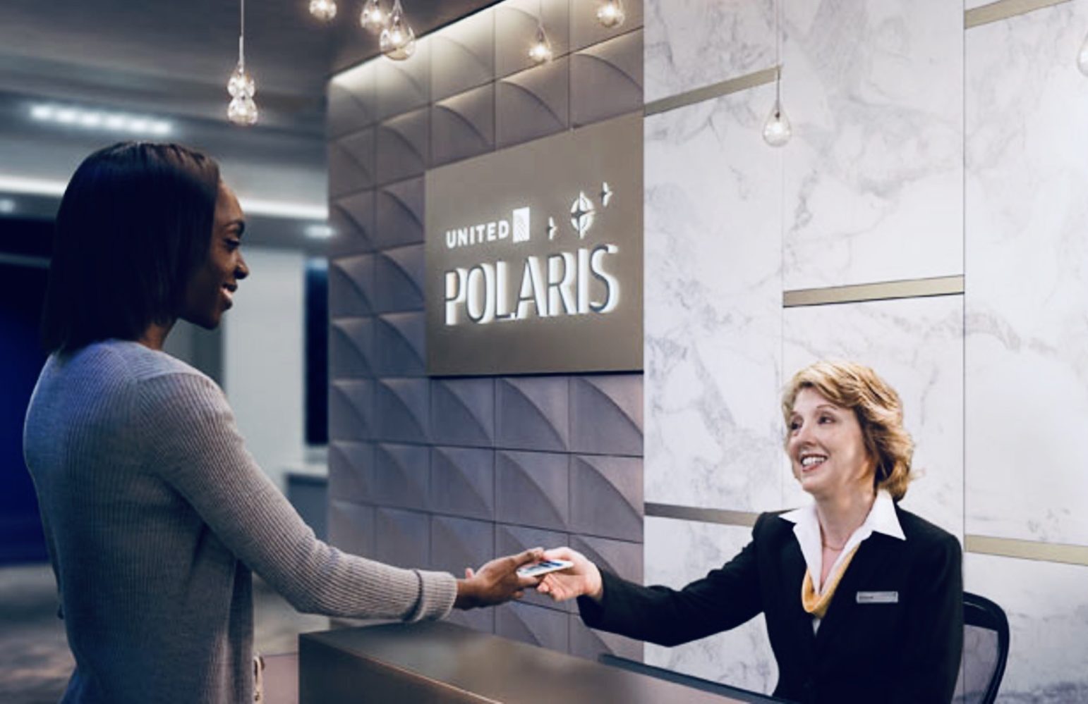 a woman handing a card to a woman at a reception