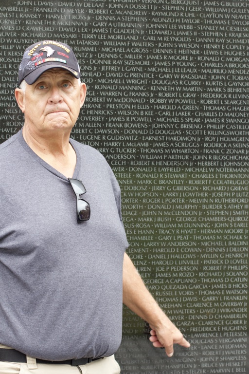 Veteran points to lost friends at The Wall at the Vietnam War Memorial
