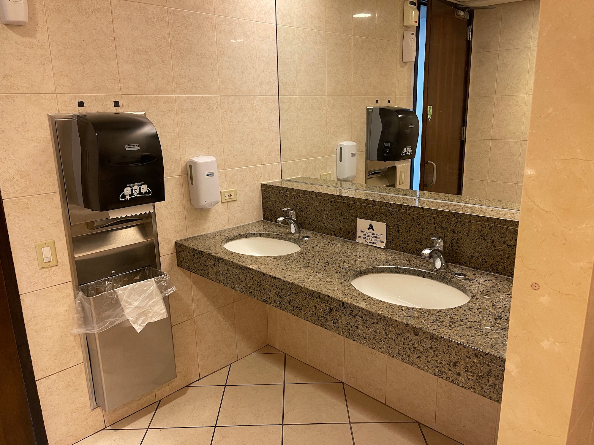 a bathroom with sinks and soap dispensers