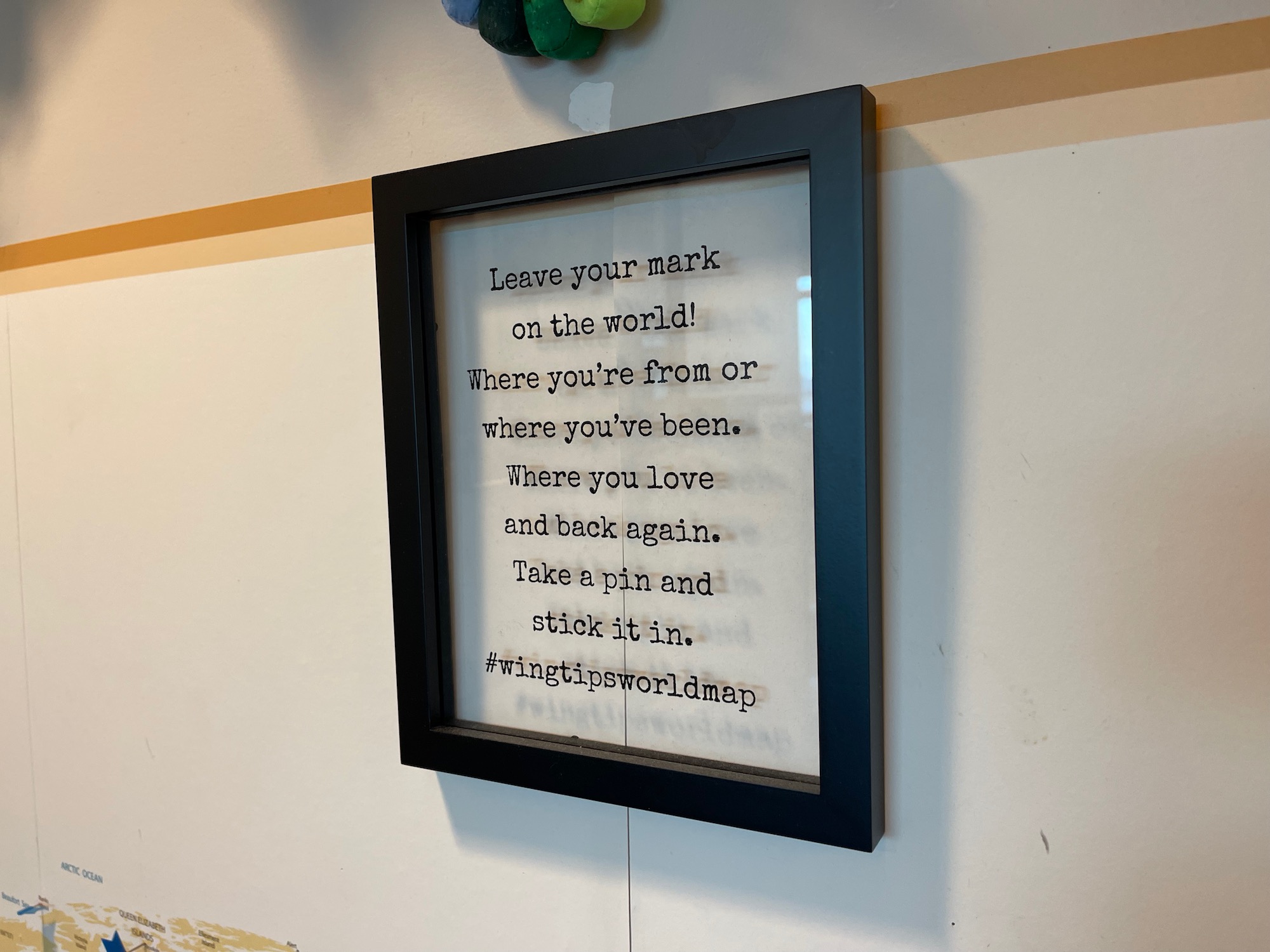 a black frame with black text on a white wall