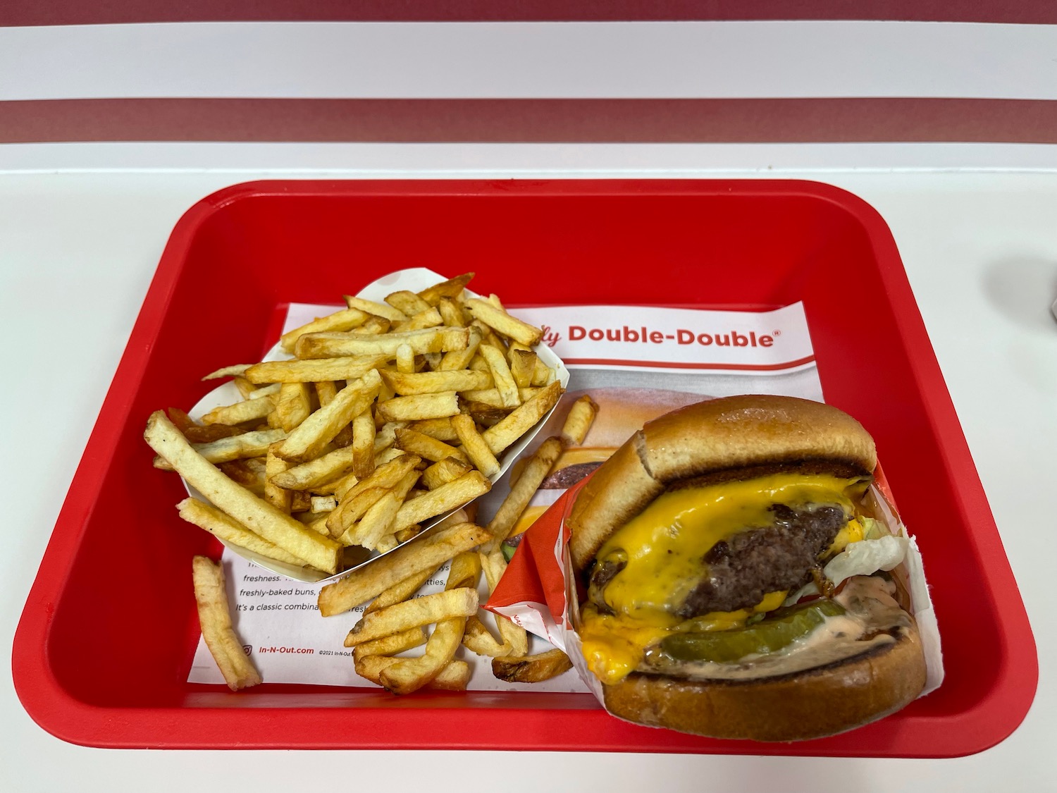 a burger and fries in a red tray