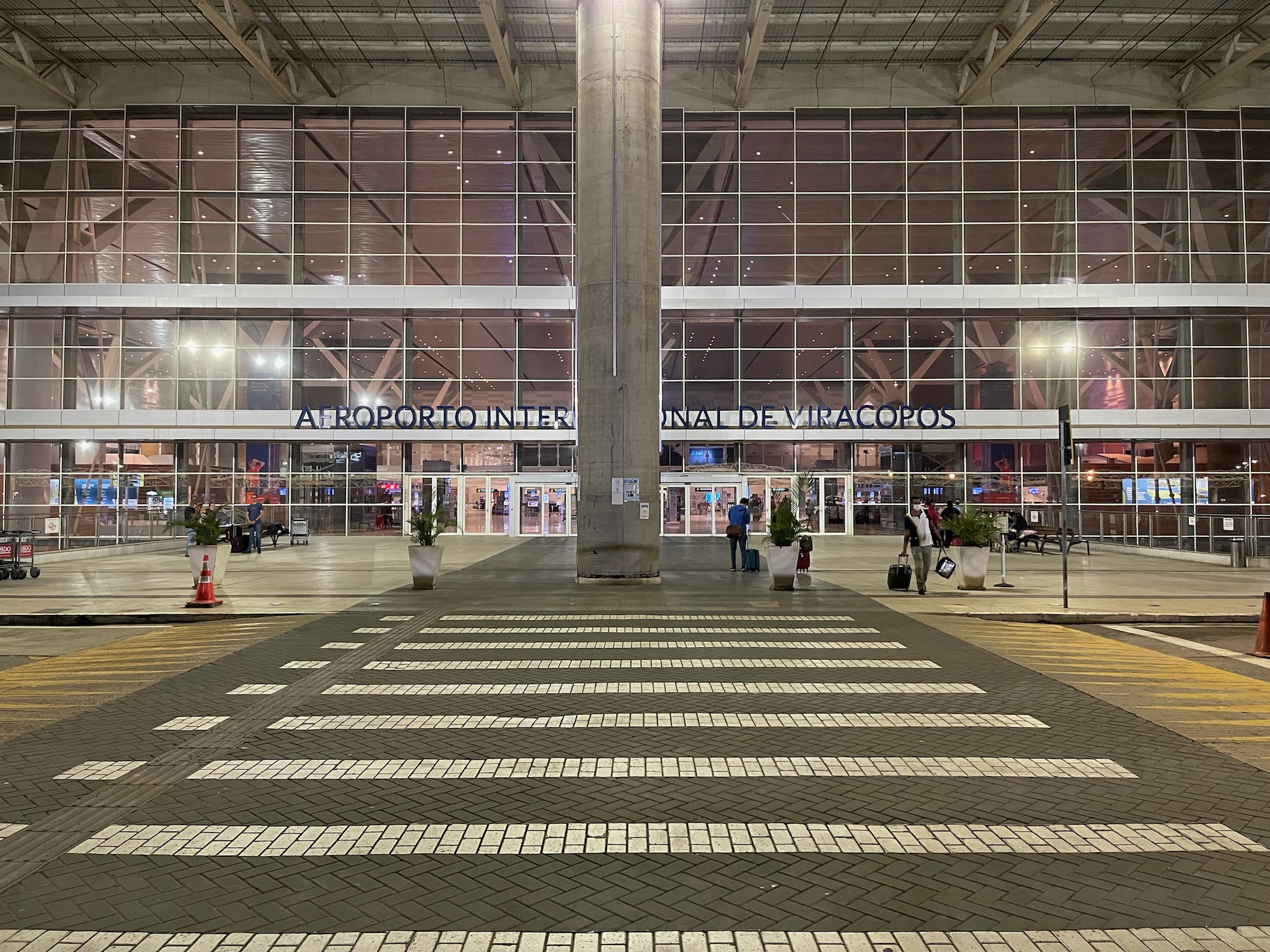 a large building with a large pole and people walking