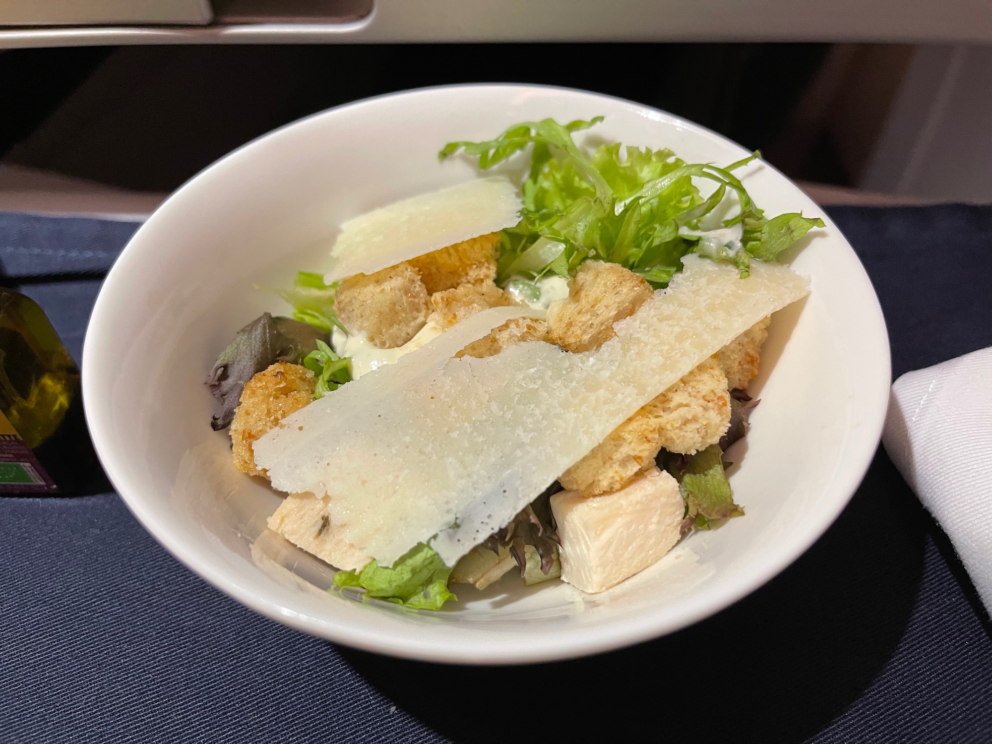 a bowl of salad with croutons and cheese