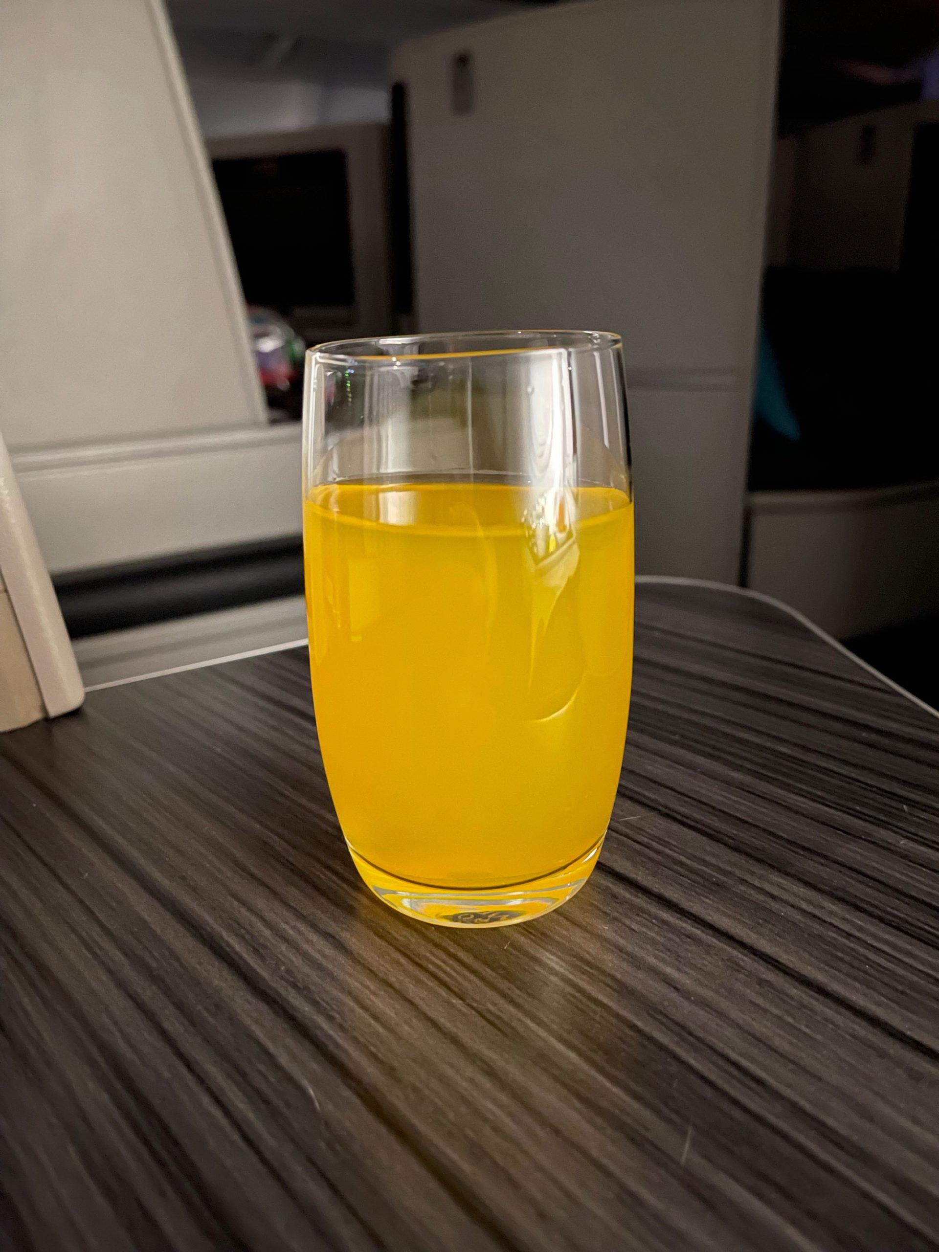 a glass of orange liquid on a table