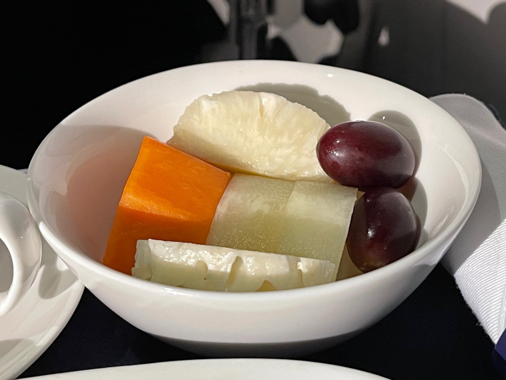 a bowl of fruit and grapes