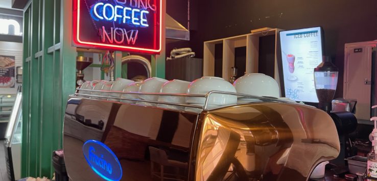 a coffee machine with a neon sign