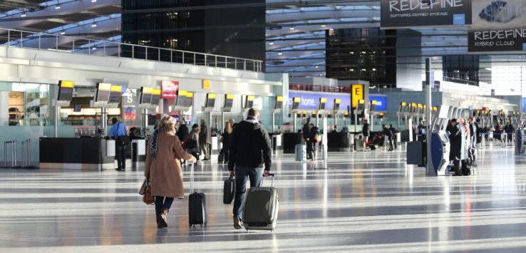 people walking with luggage in an airport