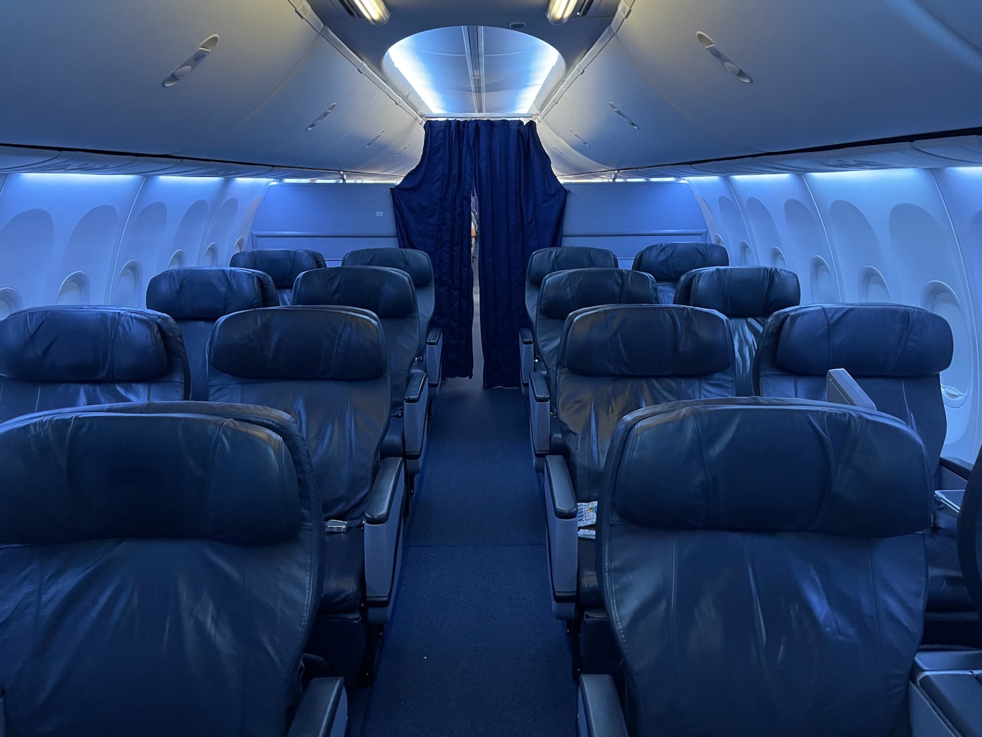 the inside of an airplane with blue curtains