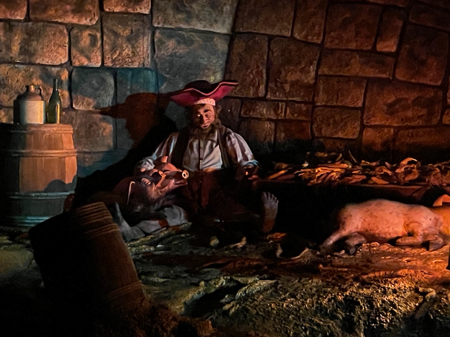 a man in pirate garment sitting next to pigs