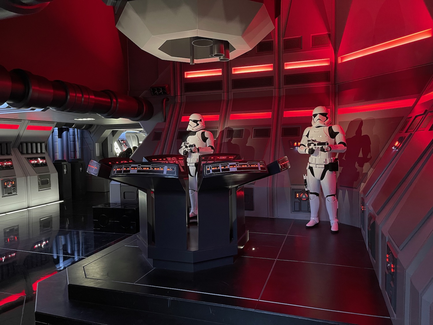 two people in clothing in a room with red lights