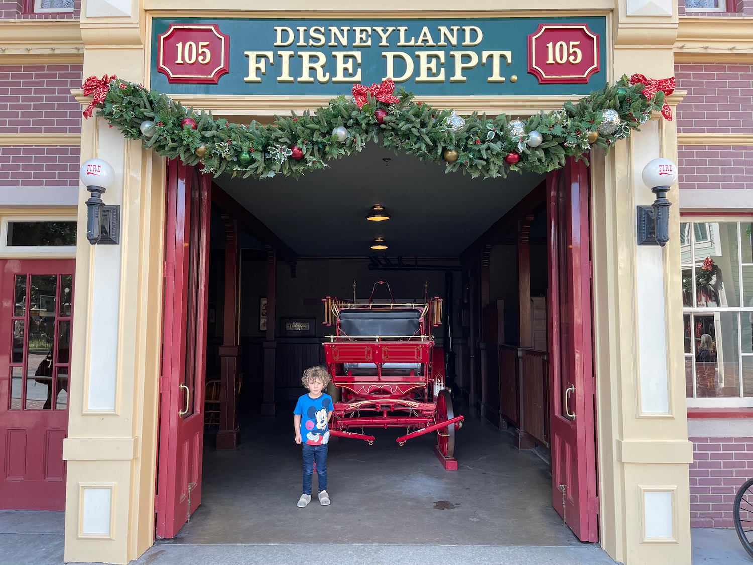 a child standing in front of a fire station