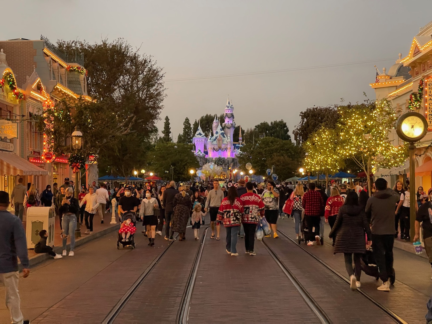 a group of people walking on a street with a castle in the background