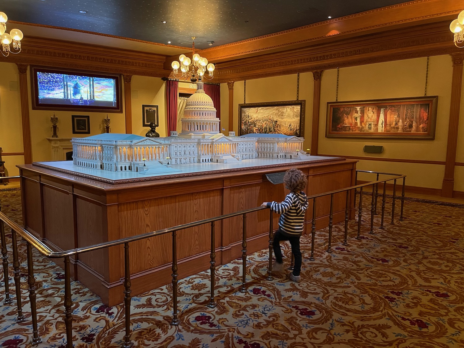 a child looking at a model of a building