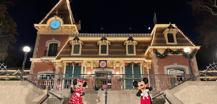 a couple of mickey and minnie mouse characters outside of a building