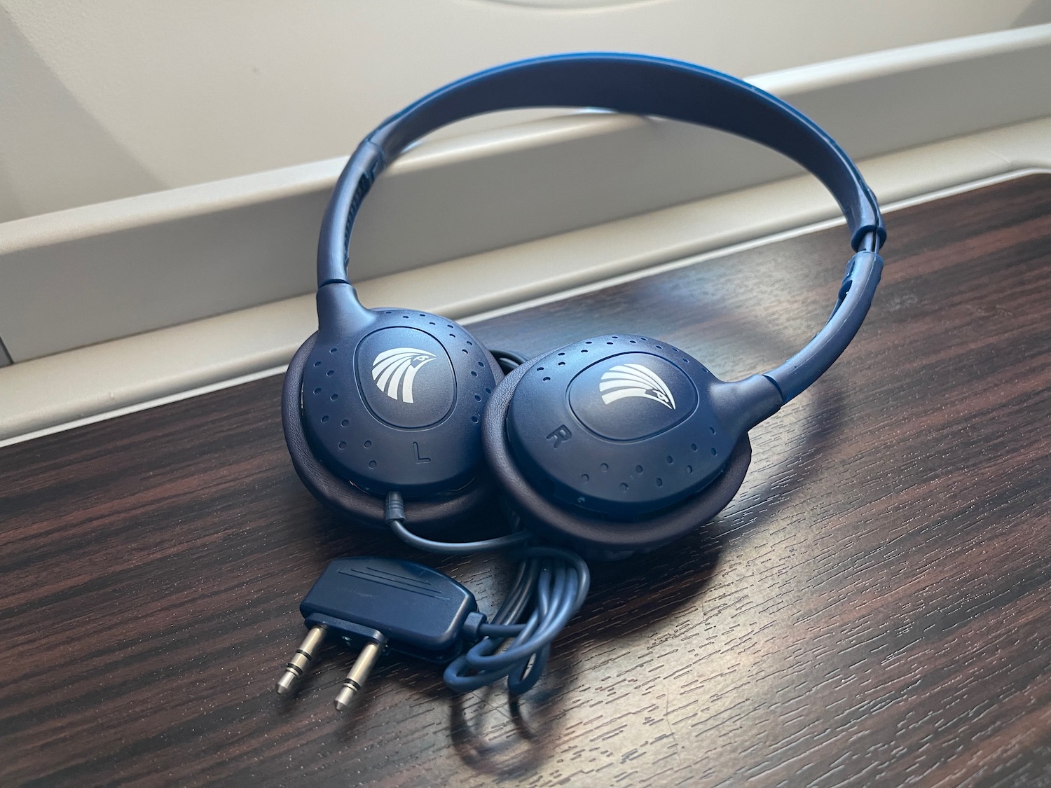 a pair of blue headphones on a wood surface