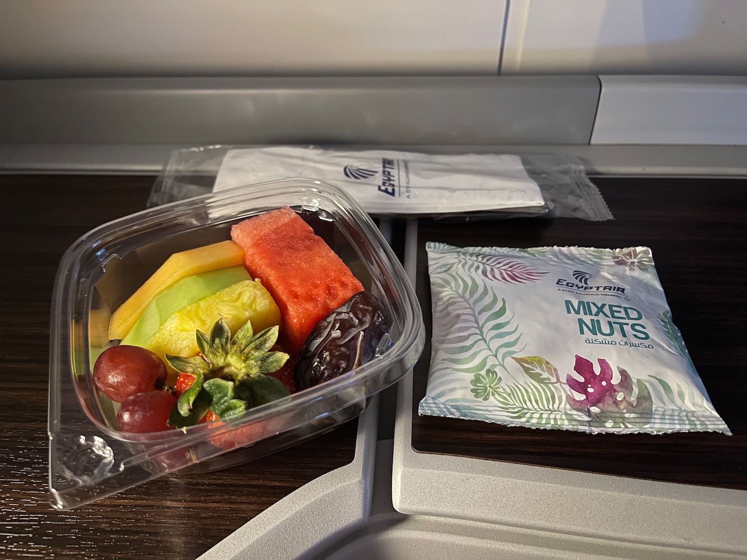 a plastic container of fruit and nuts