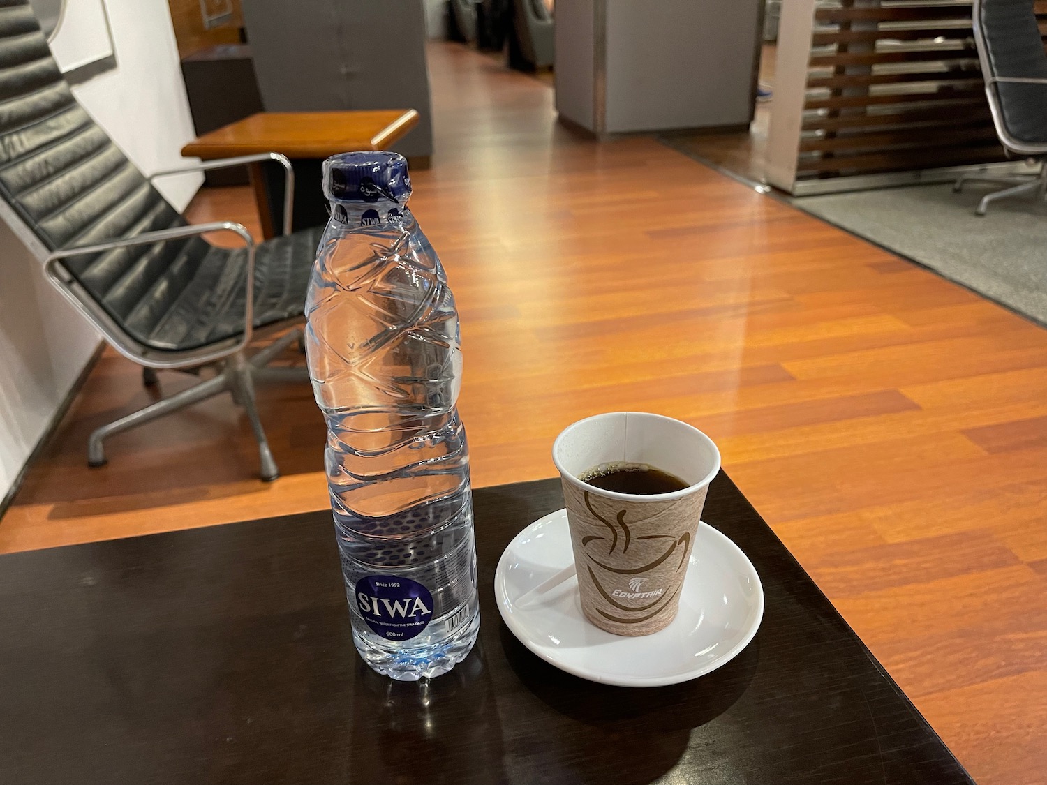 a bottle of water and a cup of coffee on a table