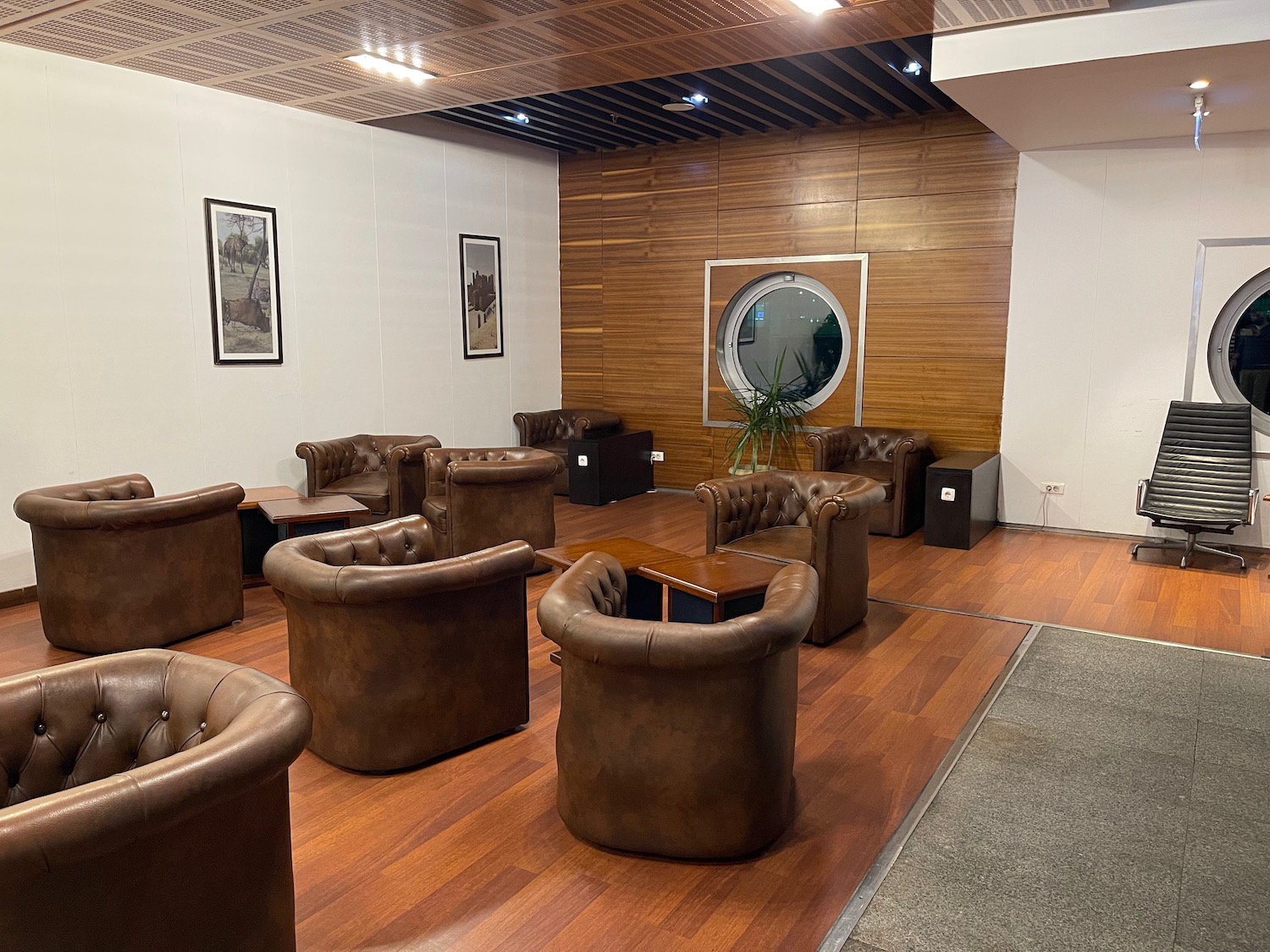 a room with brown leather chairs and a wood floor