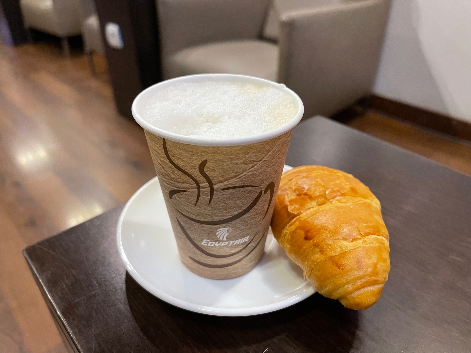 a cup of coffee and a croissant on a plate