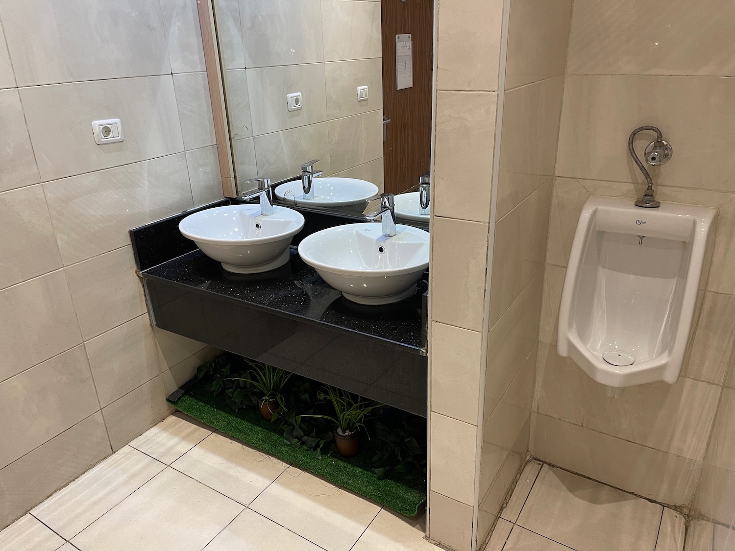 a bathroom with sinks and urinal