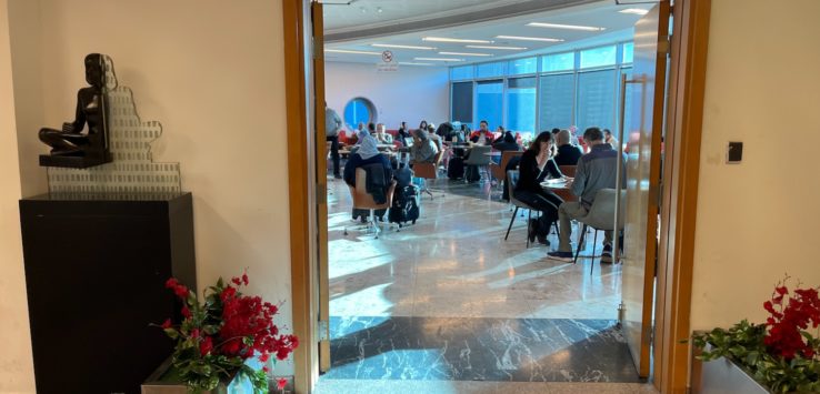 a group of people sitting at tables in a room with windows