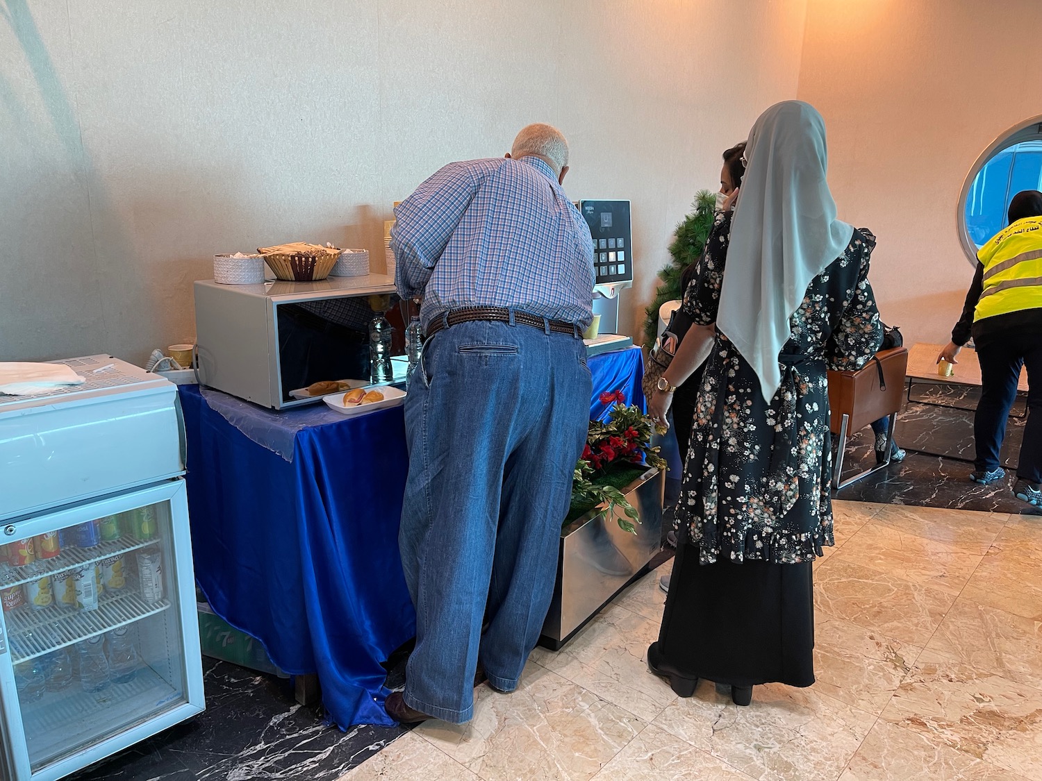 a man and woman standing in front of a microwave