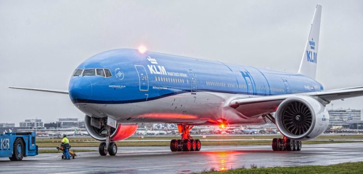 a blue and white airplane on a runway