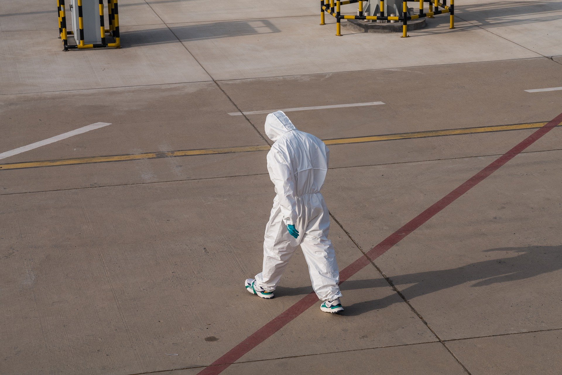 a person in a white suit walking on a concrete surface