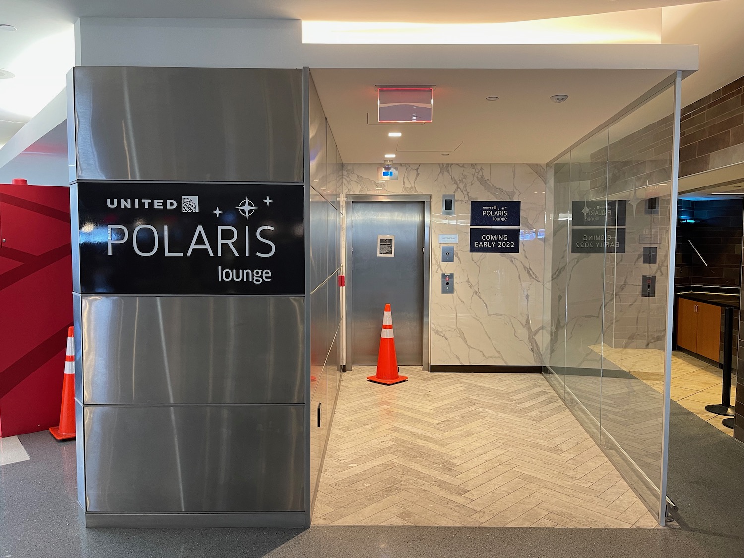 an elevator with a sign and an orange cone