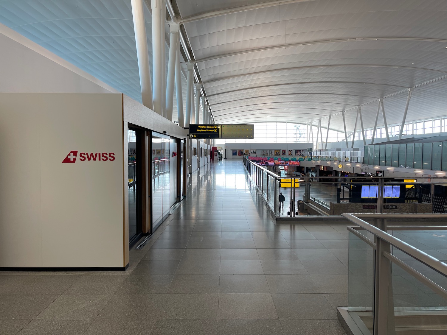 a large airport with a glass walkway and people walking