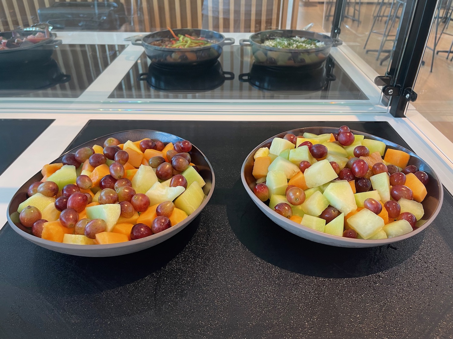 two bowls of fruit on a counter