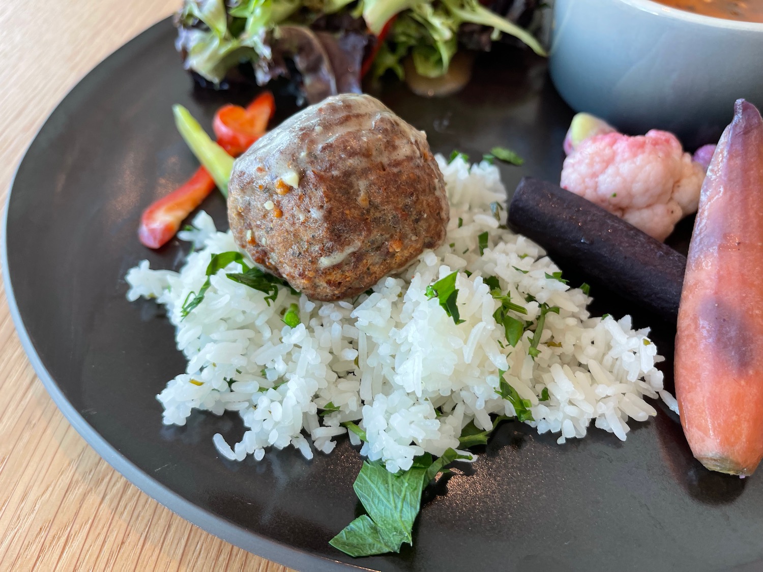a plate of food with meatball and rice