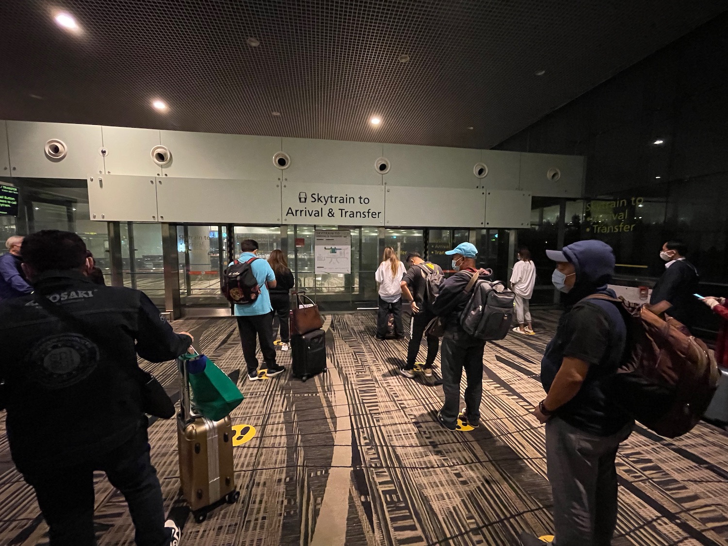 a group of people standing in a room with luggage