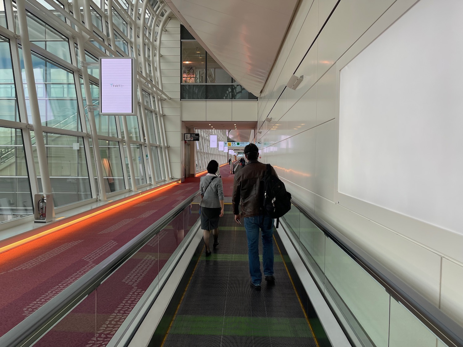 people walking down a walkway with a man and woman