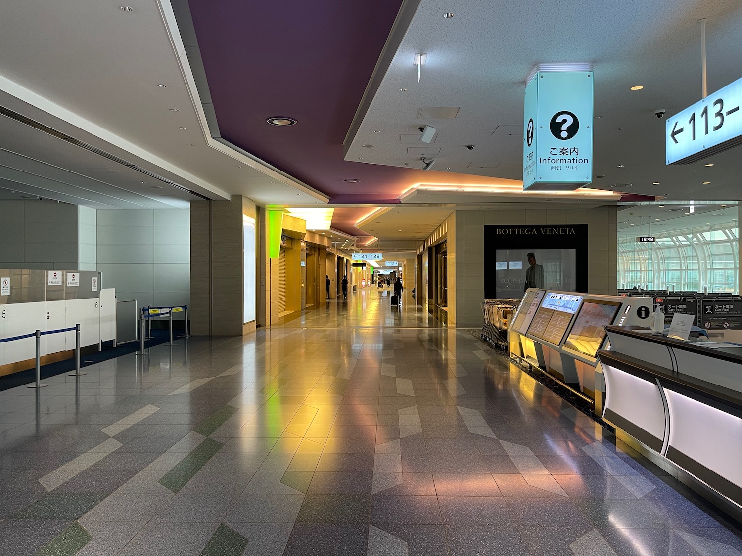 a hallway with a sign and people walking