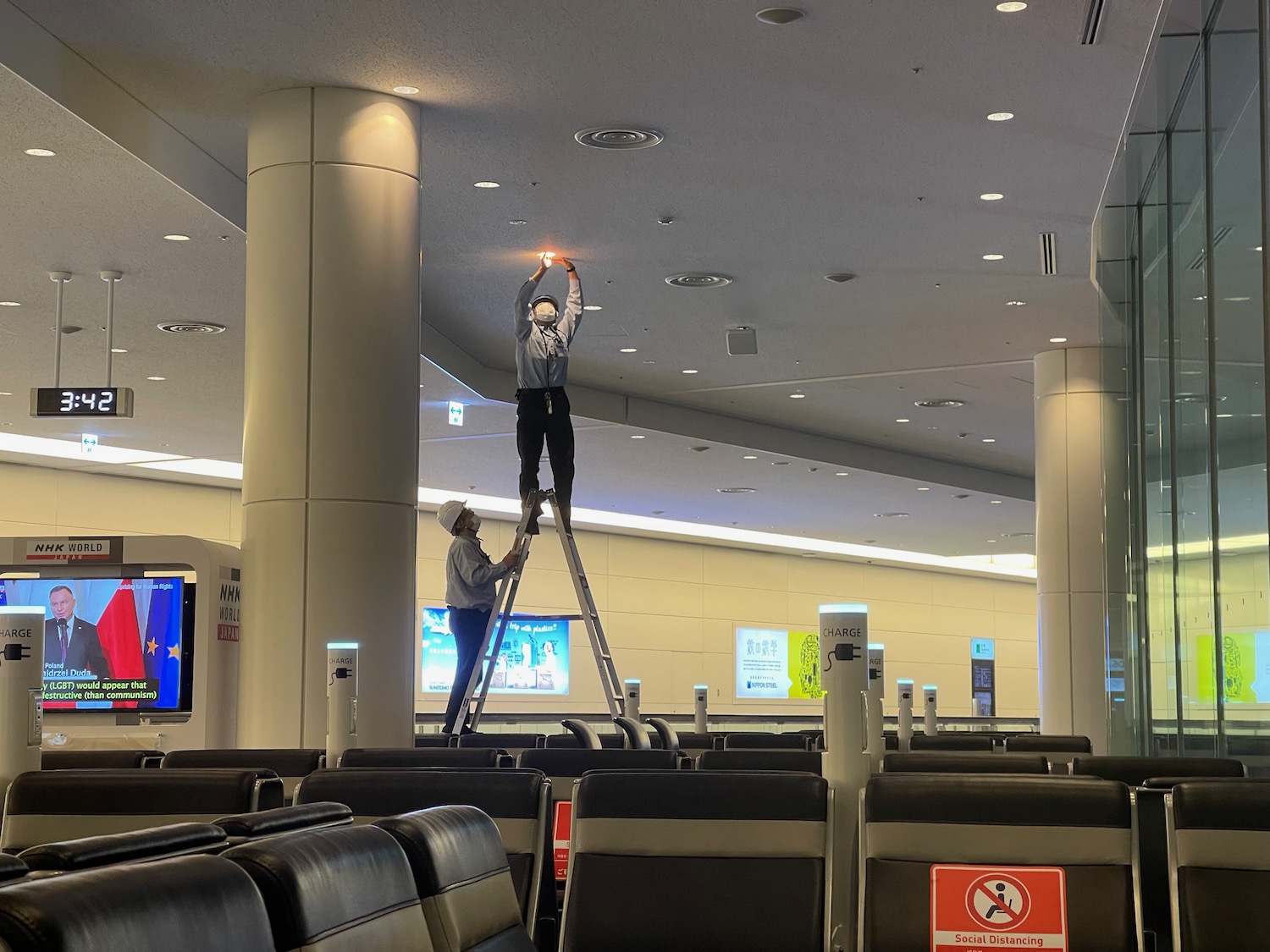 a man on a ladder in an airport