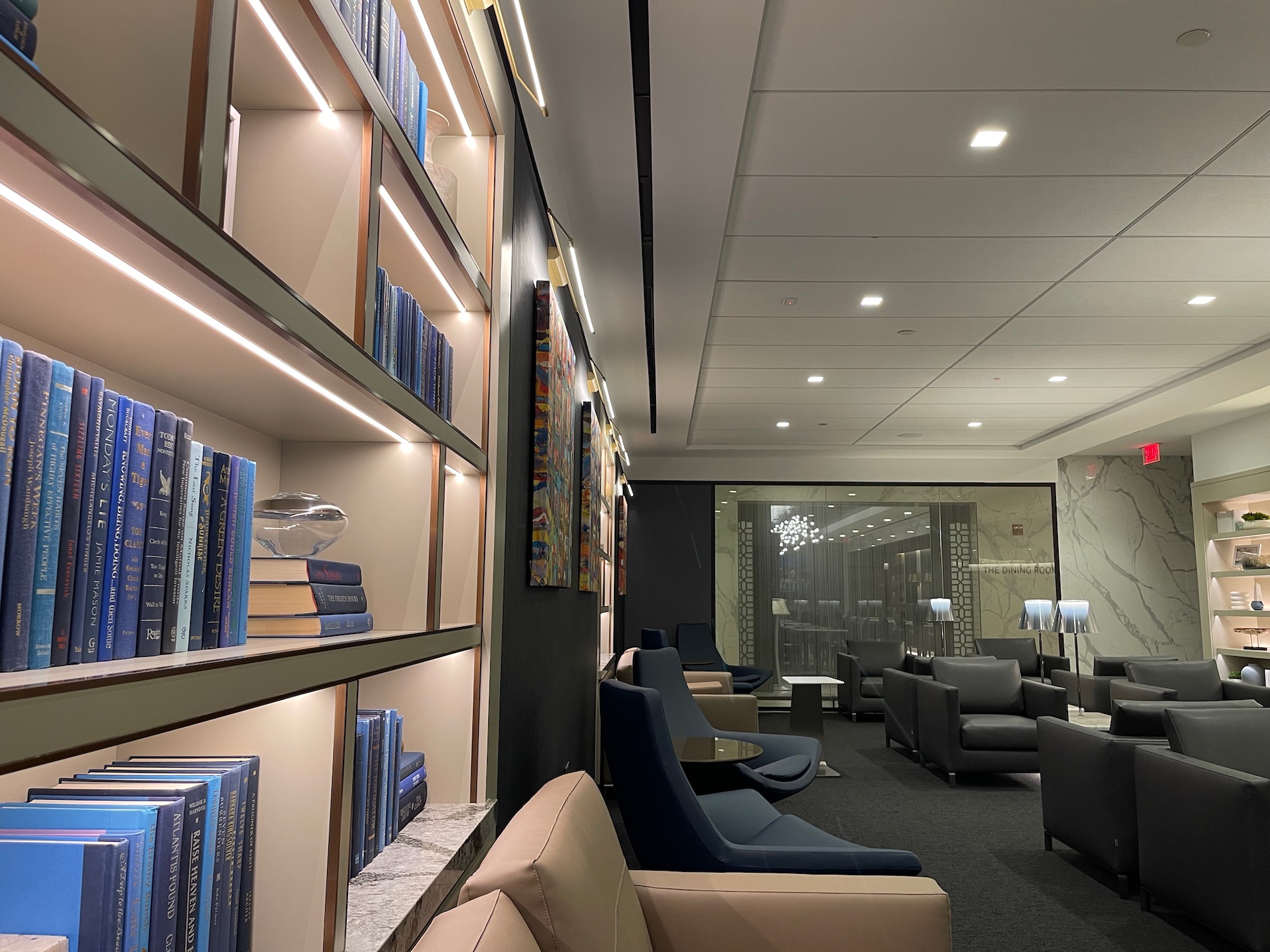 a room with a book shelf and chairs