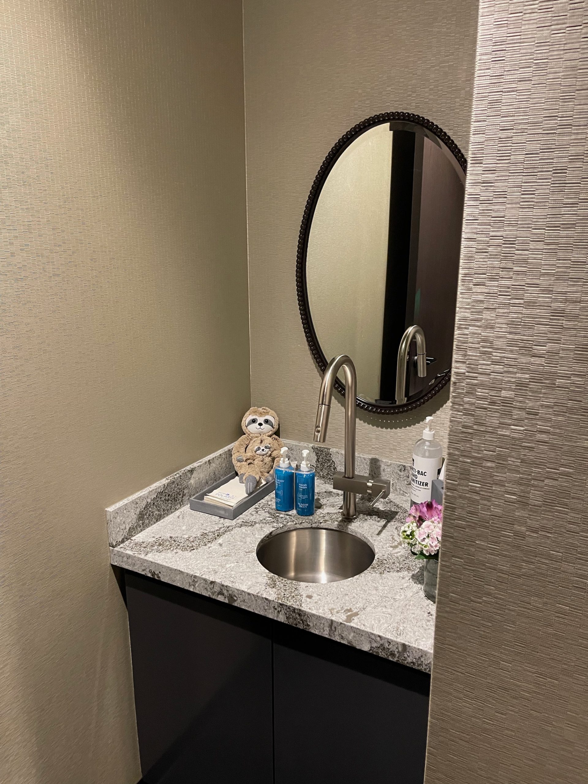 a bathroom sink with a mirror and a teddy bear