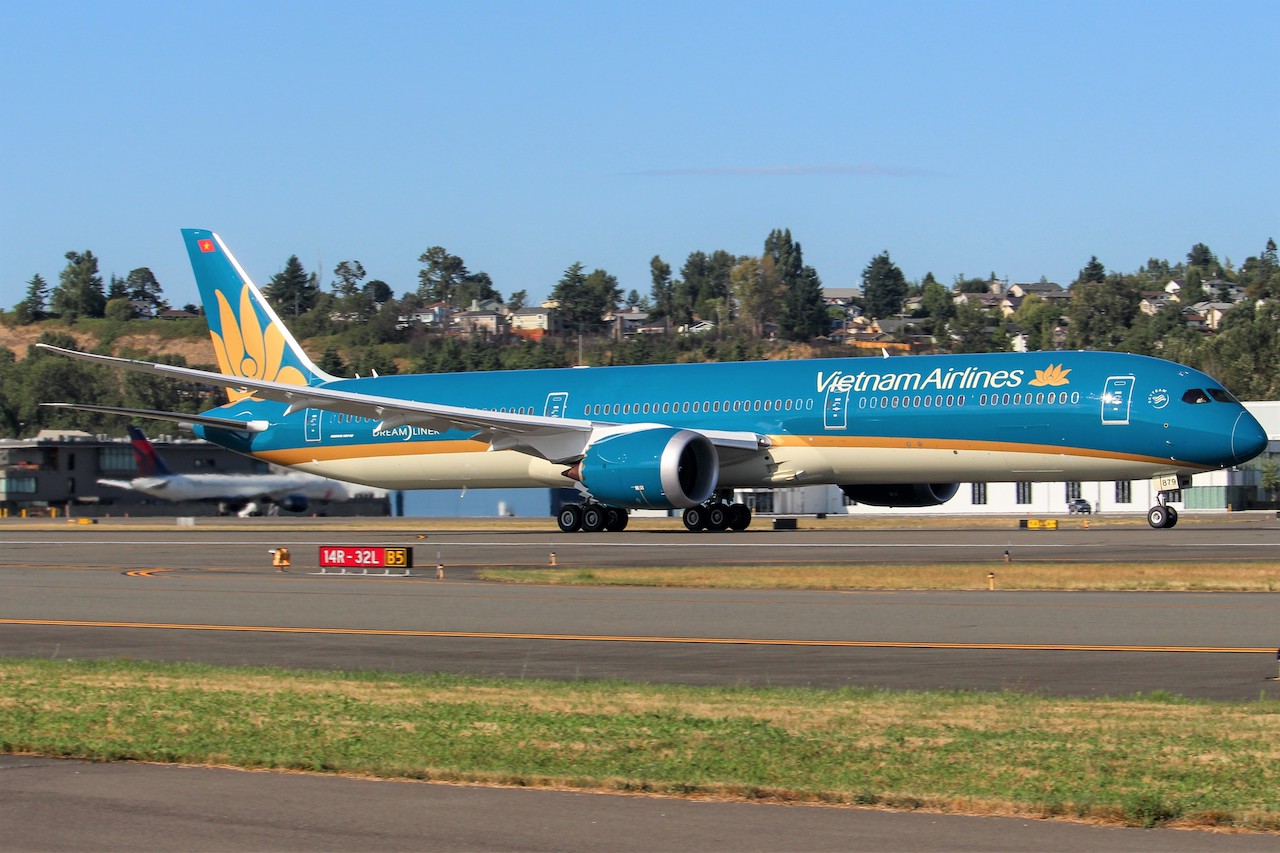 a blue and white airplane on a runway